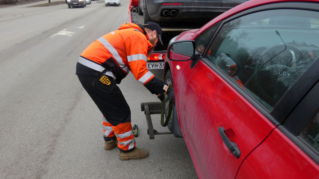 Autoa kiinnitetään hinausauton kyytiin